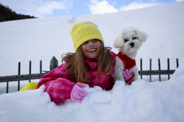 Зима, дитина, сніг - молода дівчина з собакою насолоджується зимою
 - Фото, зображення