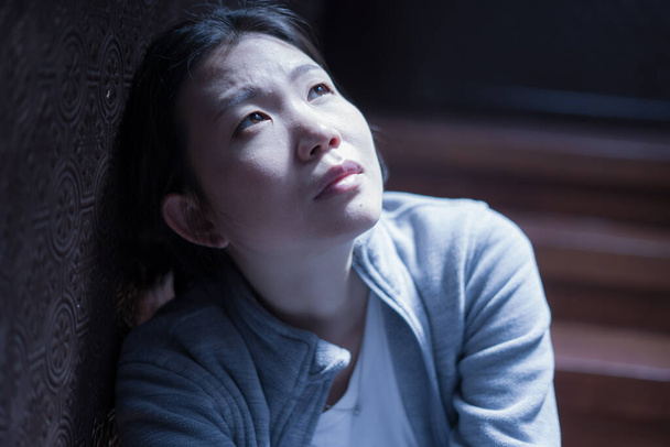 young beautiful Asian woman in pain suffering depression - dramatic indoors portrait on staircase of sad and depressed Korean girl as victim of bullying and abuse  - Foto, Bild