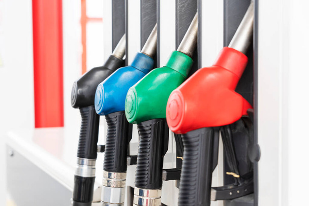 Zamknij obraz czterech pomp gazowych z różnymi rodzajami paliwa na stacji benzynowej. Proces tankowania samochodów. - Zdjęcie, obraz