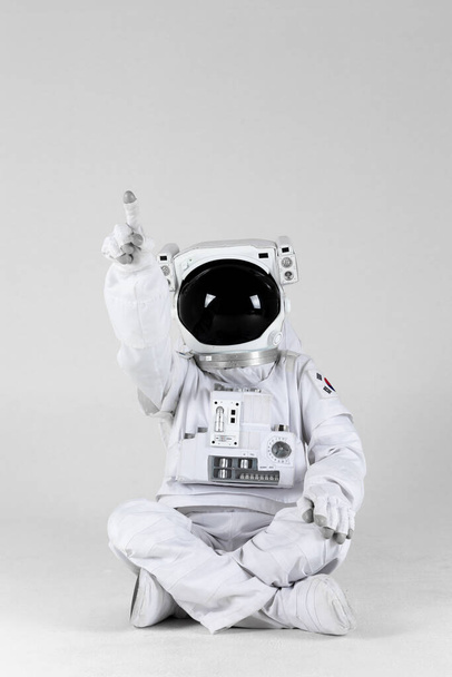 Astronaut pointing one side, white background - Foto, afbeelding