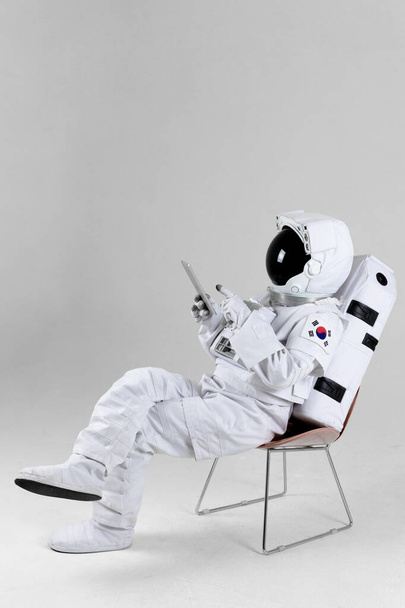 astronaut surfing Internet with tablet PC, white background - Fotoğraf, Görsel