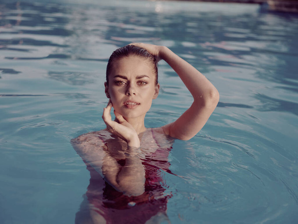vrouw in badpak in het zwembad aantrekkelijk look vrije tijd levensstijl - Foto, afbeelding