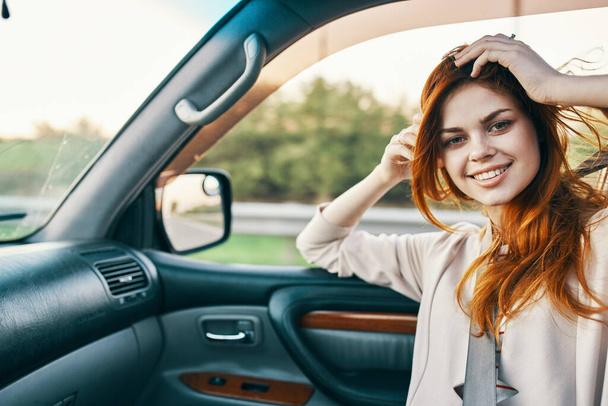 happy woman with red hair in front seat of car touching face with hands cropped view - Foto, Bild