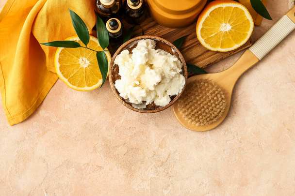 Samenstelling met sheaboter, sinaasappelfruit, borstel en cosmetische producten op kleur achtergrond - Foto, afbeelding