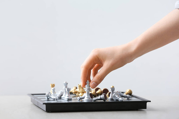 Женщина играет в шахматы на светлом фоне - Фото, изображение