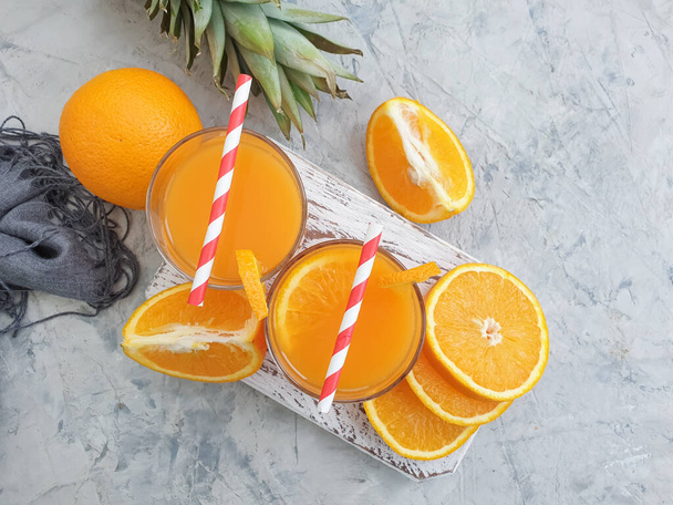 新鮮なオレンジジュースコンクリートの背景にパイナップル - 写真・画像