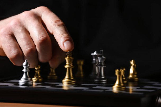 Man playing chess on dark background, closeup - Photo, Image