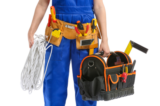 Young female electrician with tools on white background - Fotoğraf, Görsel