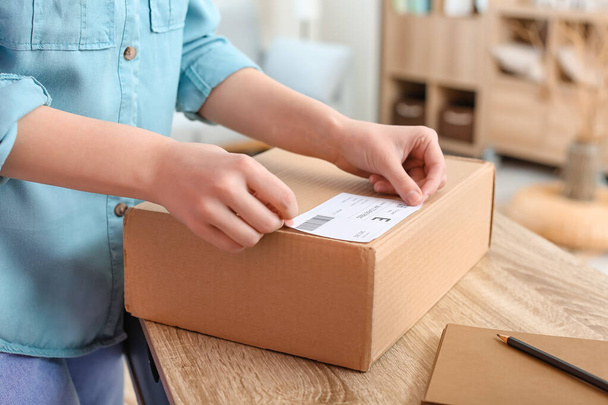 Young woman preparing parcel for client at home, closeup - Foto, immagini