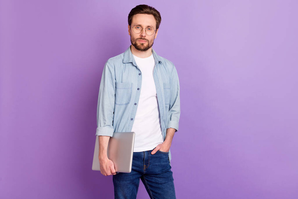 Photo of serious calm young man profession programmer hold laptop isolated on purple color background - Foto, afbeelding