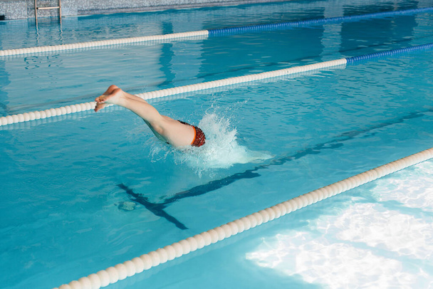A young athlete trains and prepares for swimming competitions in the pool. Healthy lifestyle. - Foto, immagini