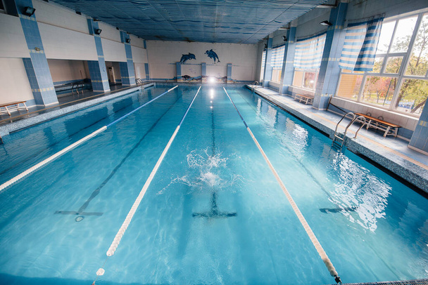 A young athlete trains and prepares for swimming competitions in the pool. Healthy lifestyle. - Fotoğraf, Görsel