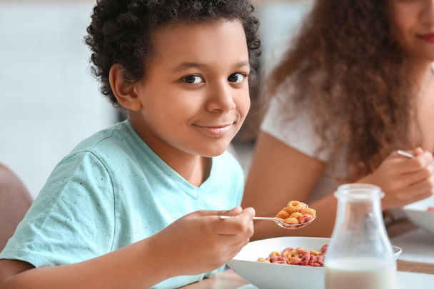 Pikkupoika, jolla on äiti syömässä maissihiutaleita kotona, lähikuva - Valokuva, kuva
