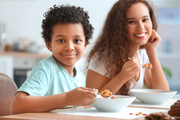 家でコーンフレークを食べる母親と小さな男の子 - 写真・画像