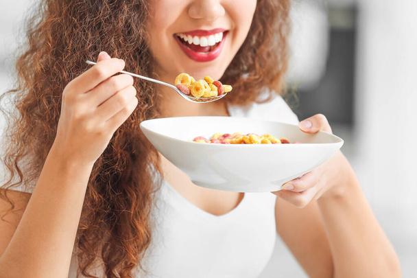 Beautiful young woman eating cornflakes at home, closeup - Φωτογραφία, εικόνα