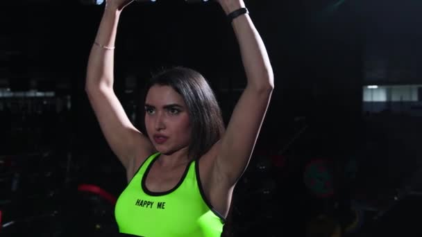 Γυμναστήριο - σπορ γυναίκα σε κίτρινο top lifting αλτήρες και την κατάρτιση των χεριών της - Πλάνα, βίντεο