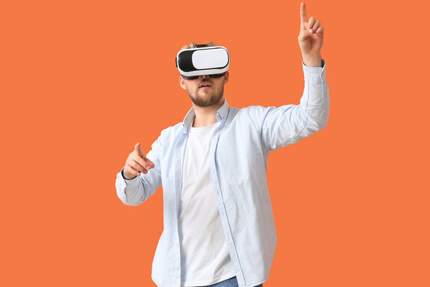 Junger Mann mit VR-Brille auf farbigem Hintergrund - Foto, Bild