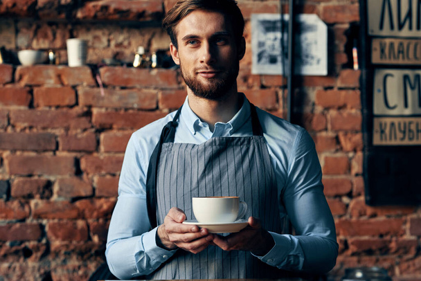 Serveur masculin service une tasse de café commande professionnelle - Photo, image