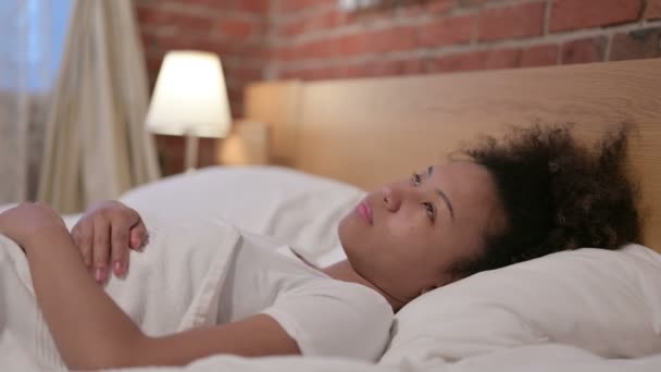 молодая африканская женщина мирно спит в постели  - Кадры, видео