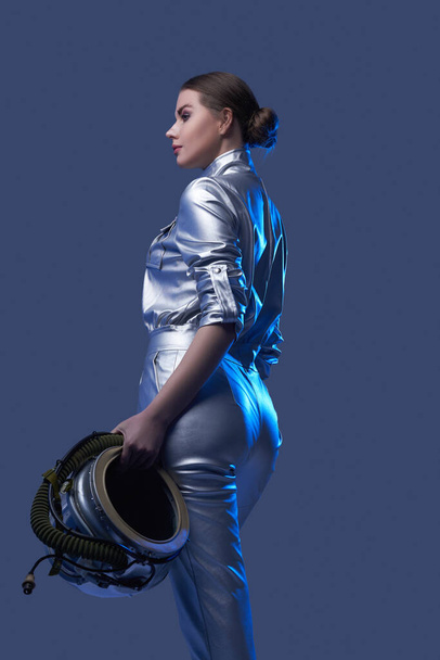 Back view of female astronaut holding helmet - Fotó, kép