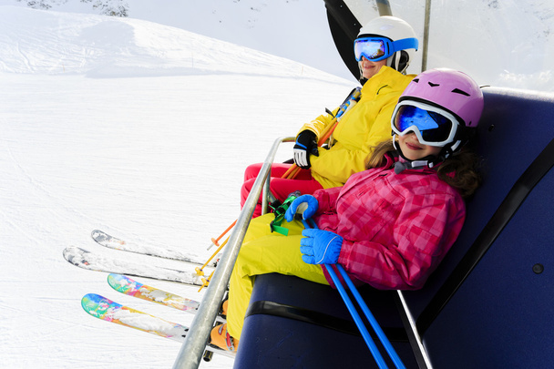Ski lift, skiing, ski resort - happy skiers on ski lift - Photo, Image