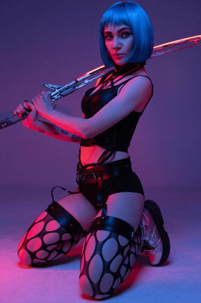 Seductive cyberpunk woman wielding glowing long sword - Photo, Image