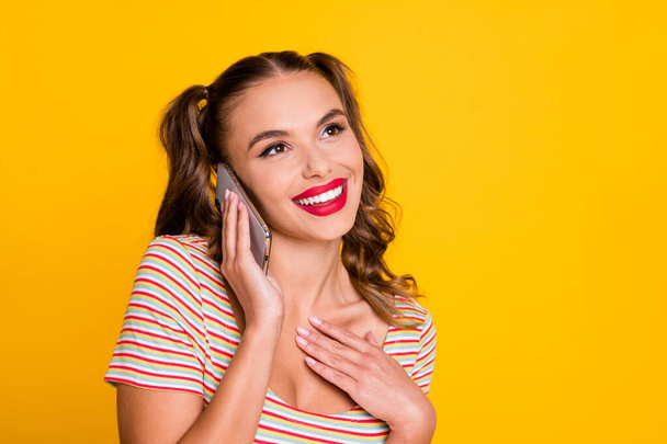 Portrait of attractive cheerful girl using gadget talking on phone enjoying good news isolated over bright yellow color background - Zdjęcie, obraz