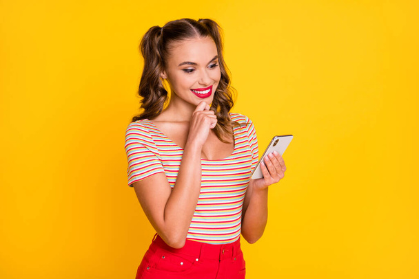 Photo of young beautiful attractive cheerful smiling positive girl blogger using smartphone isolated on yellow color background - Φωτογραφία, εικόνα