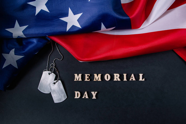 Gedenktag-Konzept. Amerikanische Flagge und militärische Hundeanhänger auf schwarzem Hintergrund. Erinnern und ehren. - Foto, Bild