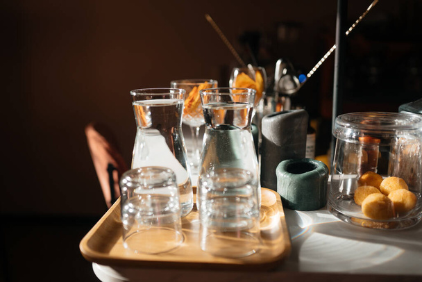 Quattro tazze di vetro sul bancone del bar con accessori di servizio. - Foto, immagini