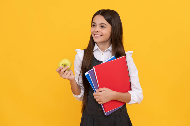 Καλώς ήρθες πίσω στο σχολείο. Χαρούμενο παιδικό χαμόγελο κρατώντας μήλο και βιβλία. Πίσω στο σχολείο. Επιστροφή στη σχολική σεζόν. 1η Σεπτεμβρίου. Ημέρα γνώσης. Βασική εκπαίδευση. - Φωτογραφία, εικόνα