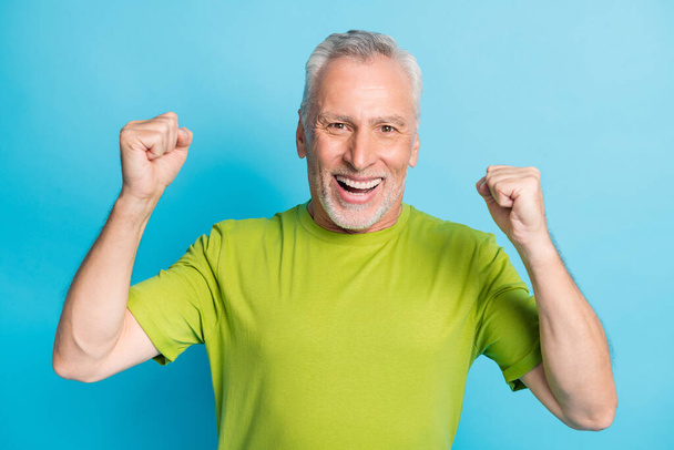 Photo of astonished positive man fists up toothy smile celebrate look camera isolated on blue color background - Фото, зображення