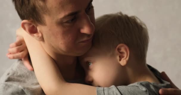 Der Vater tröstet einen aufgebrachten Sohn. Trauriger Vorschüler umarmt seinen Vater. Konflikt in der Familie. Junge in Papas Armen - Filmmaterial, Video