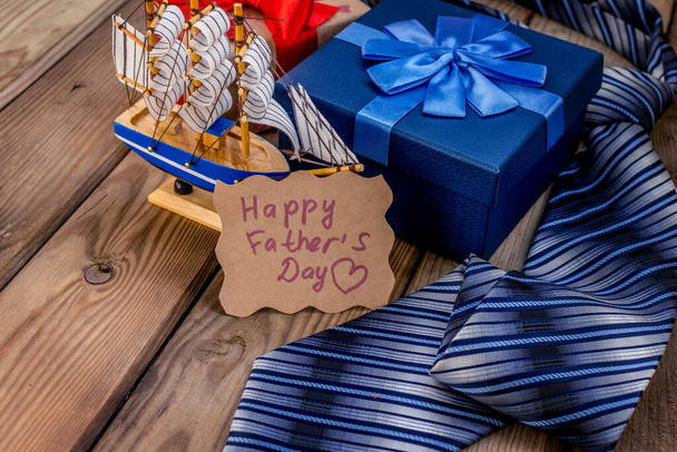 Happy Fathers Day gift box with tie on a rustic wood background. Greeting card - Valokuva, kuva