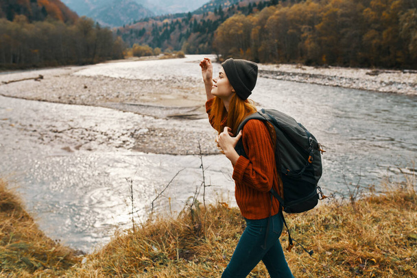 woman in autumn in the mountains with a backpack on her shoulders travel tourism river - Photo, Image