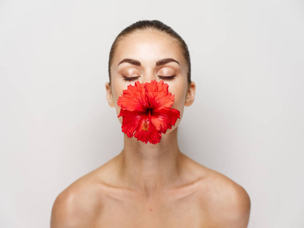 attractive woman with closed eyes flower mouth naked shoulders isolated background - Фото, зображення
