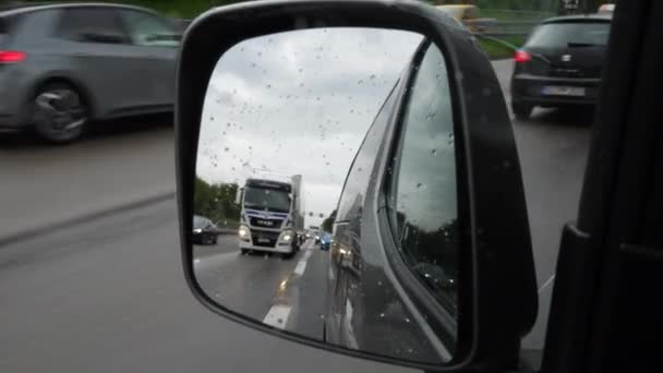 Driving on German highway on a rainy day - view through rear-view mirror - Séquence, vidéo