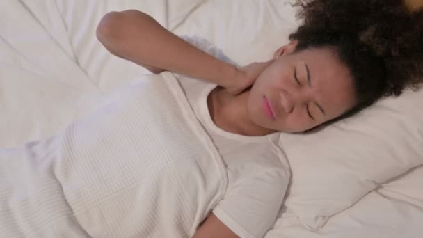 Африканская женщина испытывает боль в шее во время сна в постели - Кадры, видео