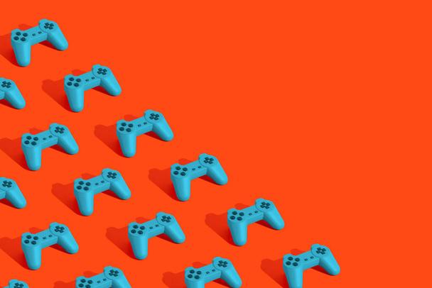 Patrón inconsútil colorido con mandos azules sobre fondo naranja. Concepto creativo de la industria de videojuegos o juegos. Copiar espacio. 3d renderizar. - Foto, imagen
