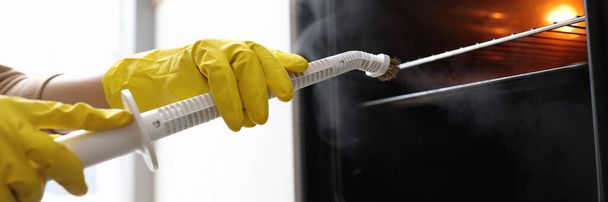 Manos en guantes de goma para lavar el horno con el concepto de vapor - Foto, Imagen