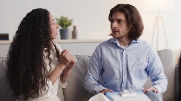 Giovani sposi emotivi che parlano a consulto psicologico personale, litigano e litigano sul divano in ufficio - Filmati, video
