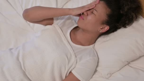 Mujer africana con dolor de cabeza mientras duerme en la cama - Imágenes, Vídeo