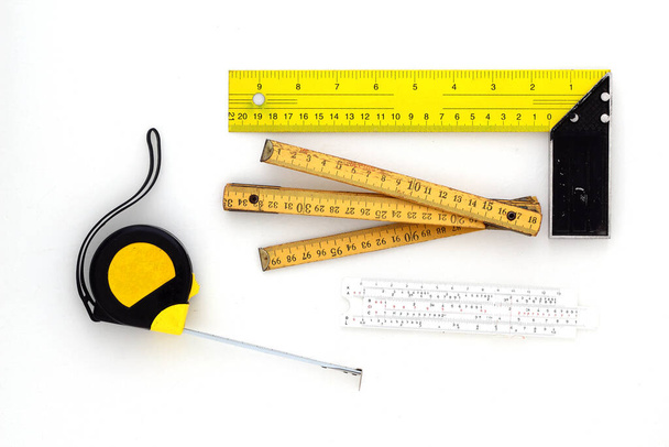 Жовта вимірювальна стрічка для рулетки або лінійки інструментів. Стрічка вимірює шаблон в сантиметрах. Набір вимірювачів стрічок ізольовано на білому тлі
. - Фото, зображення