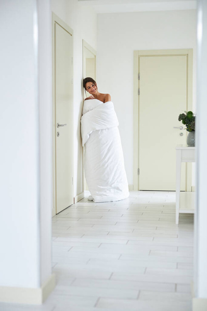 Laughing charming elegant woman posing at the camera in white corridor in the home apartment - 写真・画像