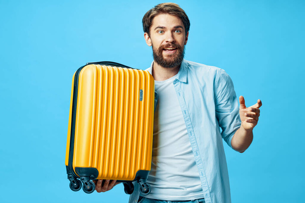 Cheerful man with yellow suitcase traveling passenger airport - Photo, image