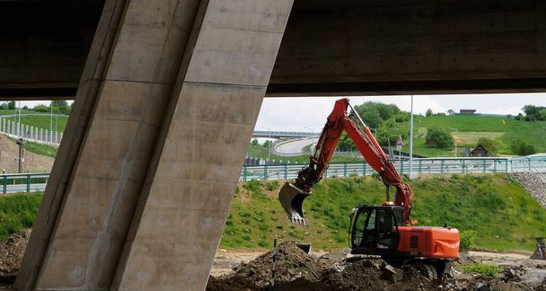 construction space, red-orange excavator, truck or bulldozer, mechanical car, bridge,  - Photo, Image