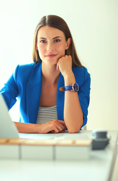 Woman sitting on the desk with laptop - Foto, imagen