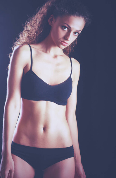 Portrait of young beautiful fitness woman, isolated on black background - Foto, afbeelding