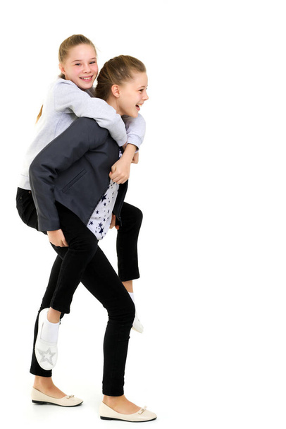 Happy Smiling Teen Girl Piggy Backing her Twin Sister - Foto, afbeelding