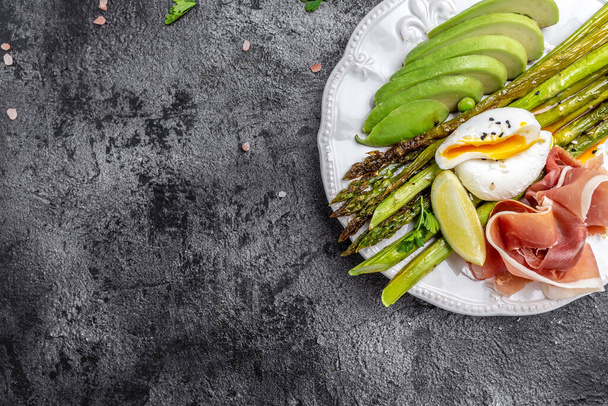 keto paleo diet baked asparagus breakfast burger with poached Egg, avocado and prosciutto, jamon, bacon. Healthy balanced food. Top view, above, banner. - Photo, Image